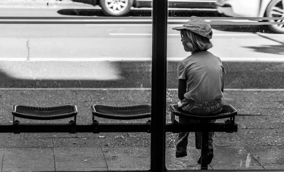 Laptop képernyőjén HTML és CSS kód látható sötét témás szerkesztőben, mellette vázlatterv weboldal készítéshez